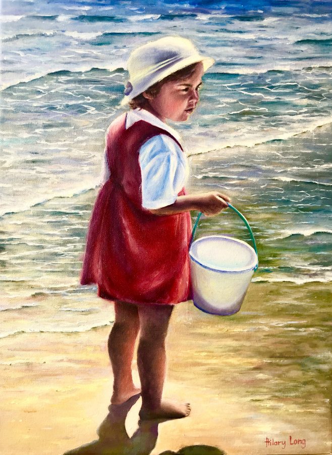 Girl with bucket by the sea shore